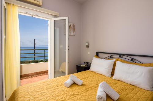 a bedroom with a yellow bed with towels on it at Asta La Vista Maisonettes in Pesádha