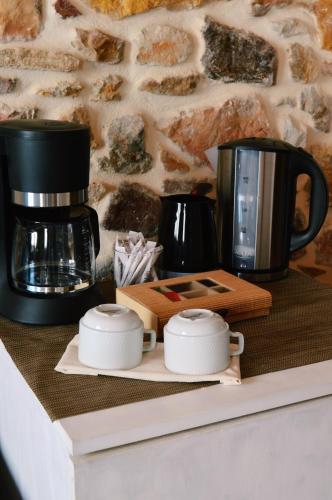 a coffee maker and two cups on a counter at Castro Rooms Chios in Chios