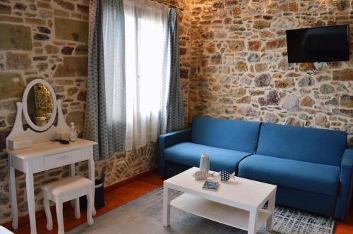 a living room with a blue couch and a mirror at Castro Rooms Chios in Chios
