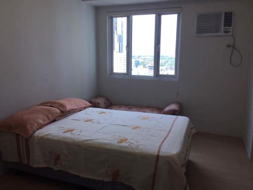 a bedroom with a bed in a room with a window at Mplace Condo Unit _ Panay Avenue, Quezon City, Philippines in Manila