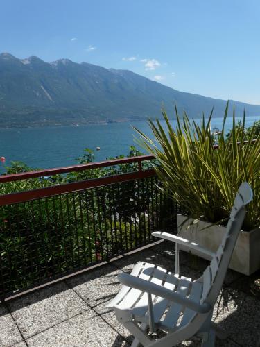 a white chair sitting on a patio overlooking the water at Hotel Lido in Limone sul Garda