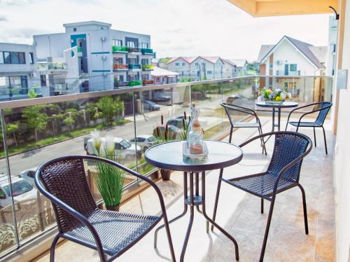 a balcony with tables and chairs and a view of a street at Roca Del Mar in Mamaia Nord