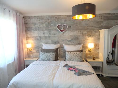 1 dormitorio con 1 cama con un corazón en la pared en Strandhotel Villa Louisa & Appartementhäuser Villa Josephine und Villa Christine, en Juliusruh