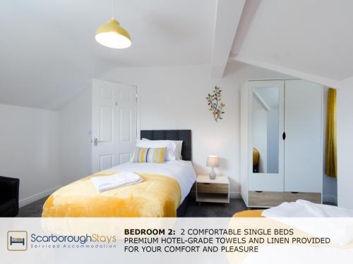 スカーバラにあるCandler Lodge - 3 BEDROOM TOWNHOUSE WITH PARKING - PATIO AREA & SEATINGの白いベッドルーム(ベッド1台、鏡付)