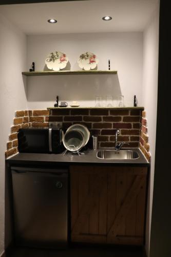 a kitchen with a sink and a microwave at Nerajoula House in Parga