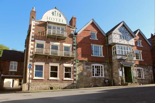 ein altes Backsteingebäude mit einem Schild, das das Hotel liest in der Unterkunft Guildhall Tavern Hotel & Restaurant in Denbigh