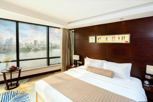 a hotel room with a large bed and a large window at Brilliant Hotel - Afternoon Tea Inclusive in Da Nang