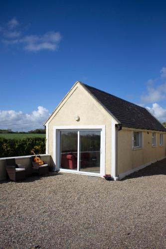a building with a large sliding glass door at Mo's Cottage in Kilmore
