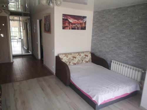 ein kleines Bett in einem Zimmer mit Ziegelwand in der Unterkunft Morskoi dom in Odessa