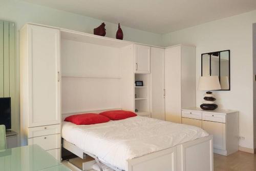 - une chambre blanche avec un lit et 2 oreillers rouges dans l'établissement C045-Lovely apartment - private residence over the sea, à Cannes