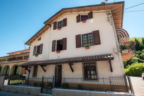 a white building with brown shutters and windows at Casa Vacanze Dante in Gorfigliano