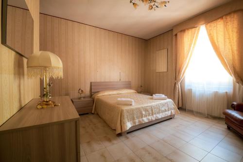 a bedroom with a bed and a table and a window at Casa Vacanze Dante in Gorfigliano