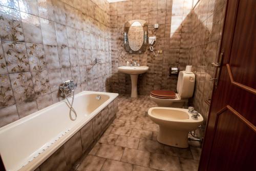 a bathroom with a tub and a toilet and a sink at Casa Vacanze Dante in Gorfigliano