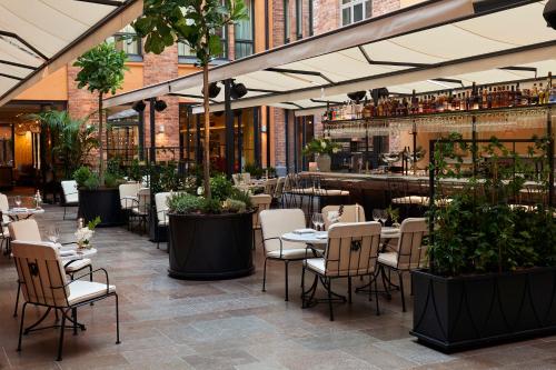 
a patio area with tables, chairs and umbrellas at Villa Dagmar in Stockholm
