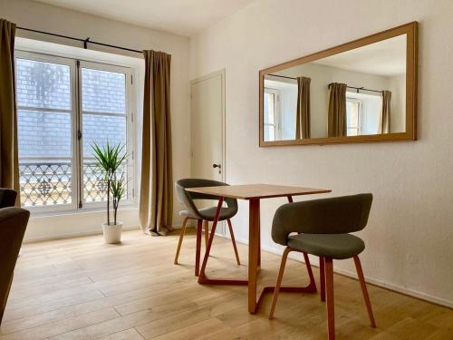 une salle à manger avec une table, des chaises et un miroir dans l'établissement Burdigala Homes - Appart de Saige, à Bordeaux