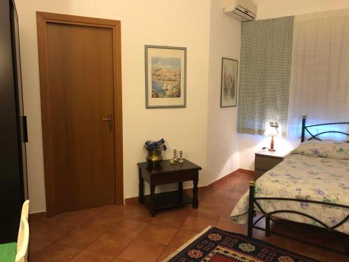 1 dormitorio con cama, mesa y puerta en Great Sicily en Mondello