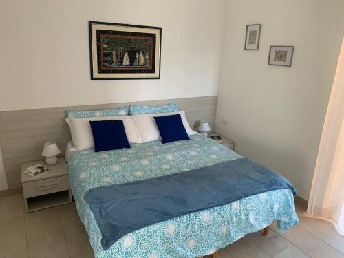 um quarto com uma cama com um edredão e almofadas azuis em B&B Al Ponte em Potenza