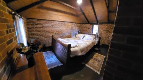 a small room with a bed in a brick wall at The Gate House in Hoddy Well