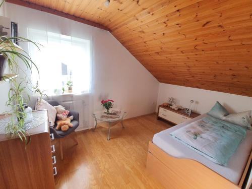 a bedroom with a bed and a wooden ceiling at Haus Heidi in Freyung