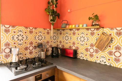 uma cozinha com um balcão com um fogão e uma parede com problemas em Gites de la Lurette - T3 lumineux et spacieux dans cadre calme et verdoyant em Cazilhac