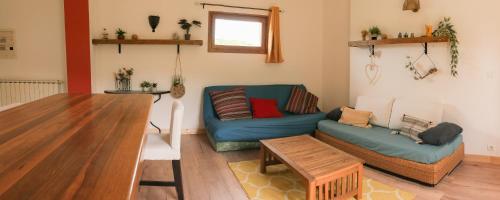 - un salon avec un canapé bleu et une table dans l'établissement Gites de la Lurette - T3 lumineux et spacieux dans cadre calme et verdoyant, à Cazilhac