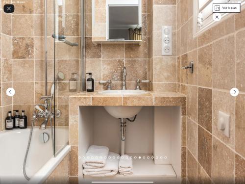 une salle de bain avec un lavabo et une douche dans l'établissement brouilly apartment one block from Eiffel Tower, à Paris