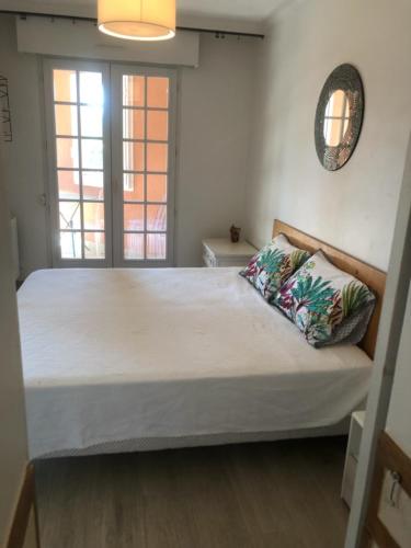 un grand lit dans une chambre avec une grande fenêtre dans l'établissement Belle résidence au centre de Saint Tropez avec piscine et garage, à Saint-Tropez