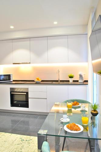 a kitchen with a glass table with food on it at Holihome Rambla 24 in Alicante