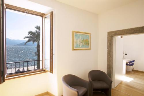 a room with a window with a view of the ocean at IseoLakeRental - Borgo Lago in Riva di Solto