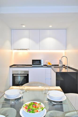 a kitchen with a glass table with a plate of food at Holihome Rambla 24 in Alicante