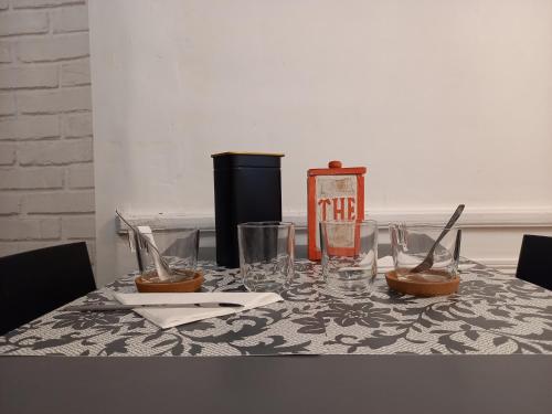 a table with glasses and utensils on it at Charmant studio dans le Vieux Tours in Tours