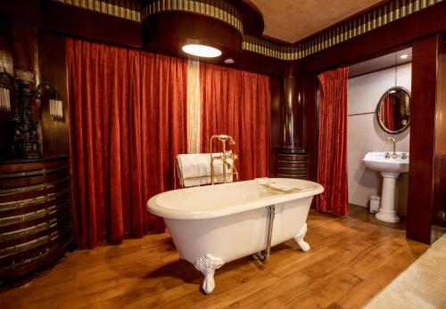 a large bathroom with a tub and a sink at Hotel Esperance in Brussels