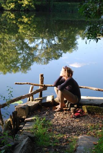 a woman sitting on the edge of a body of water at Côte du Jardin in Pouillé