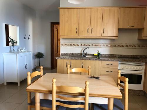 雷斯廷加的住宿－LAS CALMAS，厨房配有木桌、椅子和水槽