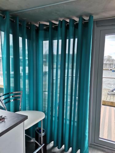 a room with blue curtains next to a window at MOONLIGHT HOUSEBOAT in Świnoujście
