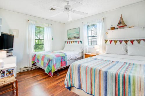 a bedroom with two beds and a flat screen tv at The Seashell Cottage in Ocean City