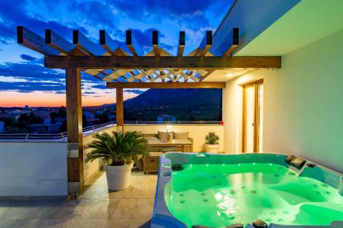 a bathroom with a green tub on a balcony at Villa Grandioza in Seline