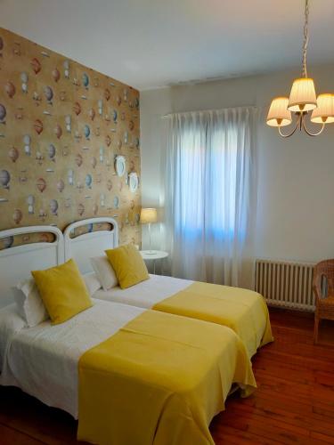 a bedroom with two beds with yellow sheets at Casa castro in Cruces