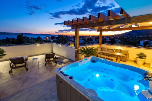 a hot tub on the balcony of a house at Villa Grandioza in Seline