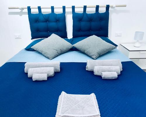 una camera da letto con un letto blu e asciugamani di Mare & Scogli a Polignano a Mare