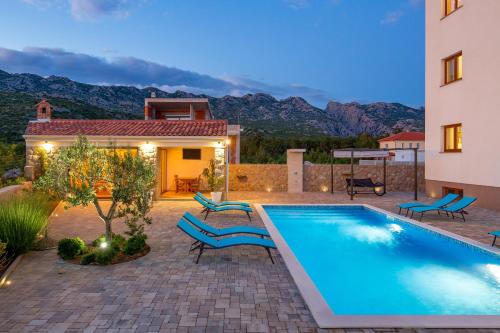 a villa with a swimming pool and a house at Villa Grandioza in Seline