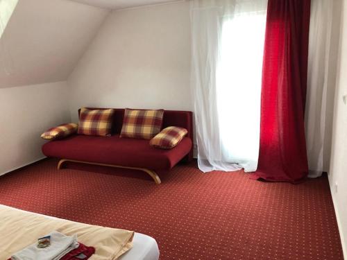 a living room with a couch and a window at Hotel Saarland Lebach in Lebach