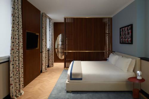 a bedroom with a white bed and a television at Amabilia Suites in Milan