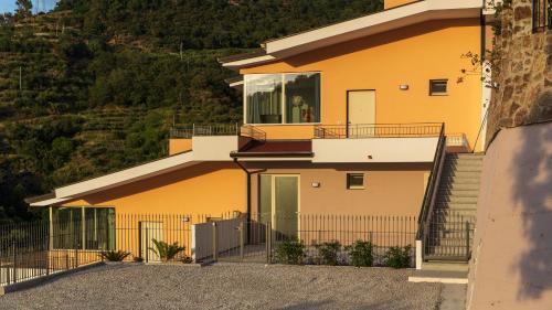 a yellow house with a balcony and a fence at Residence Mersa in Brolo