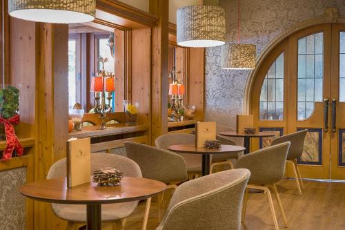 a restaurant with four tables and chairs and windows at Ringhotel Mönch`s Waldhotel in Unterreichenbach