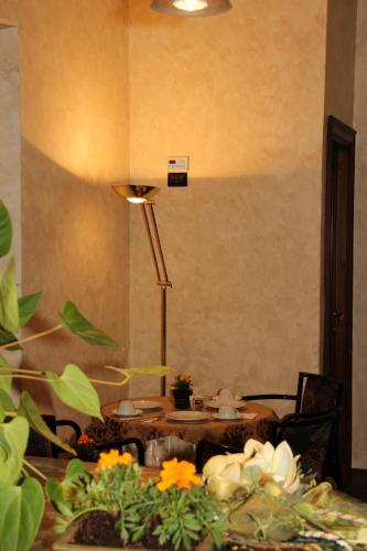 a table with a lamp and a table with flowers at Hotel Valentino Centro Storico in Orvieto