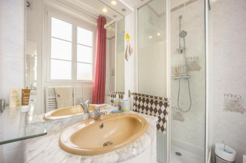 une salle de bain avec un lavabo et une douche dans l'établissement La Roseraie, à Bernières-sur-Mer