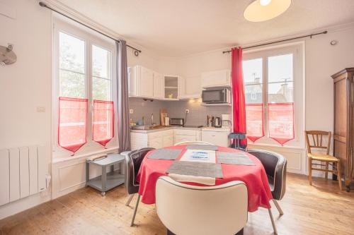 une cuisine avec une table et des chaises dans une pièce dans l'établissement La Roseraie, à Bernières-sur-Mer