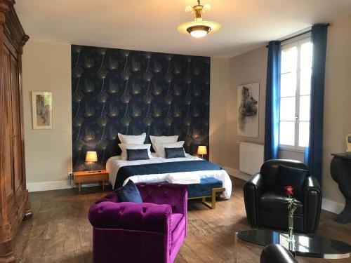 ein Schlafzimmer mit einem Bett und einem lila Sofa in der Unterkunft L'Arche de Moissac in Moissac