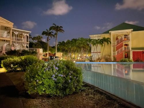 a resort with a swimming pool at night at Villa Créole Domaine privé de l'Anse des Rochers in Saint-François